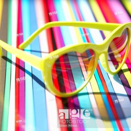 Heart shaped sunglasses on a multi coloured stripey background
