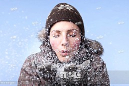 Young woman blowing snow, close_up