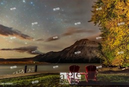 A nightscape scene at Linnet Lake area in Waterton Lakes National Park, looking east over Upper Waterton Lake and toward Vimy Peak, with autumn stars ...