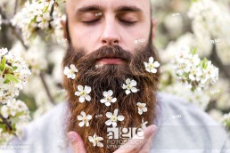Portrait of hipster with white tree blossoms in his beard